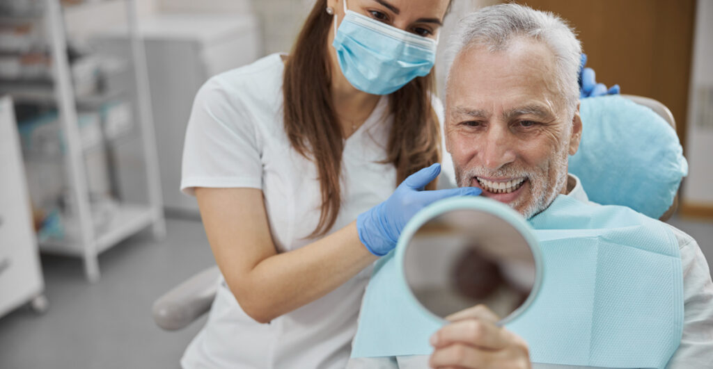 man at dentists dental implant factors affect cost