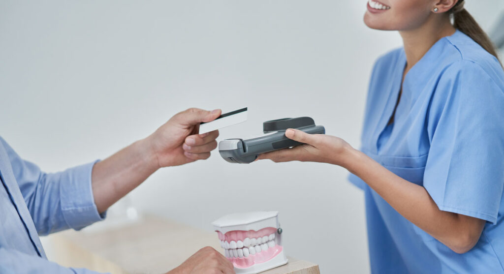 man paying additional cost of dental implants in the uk