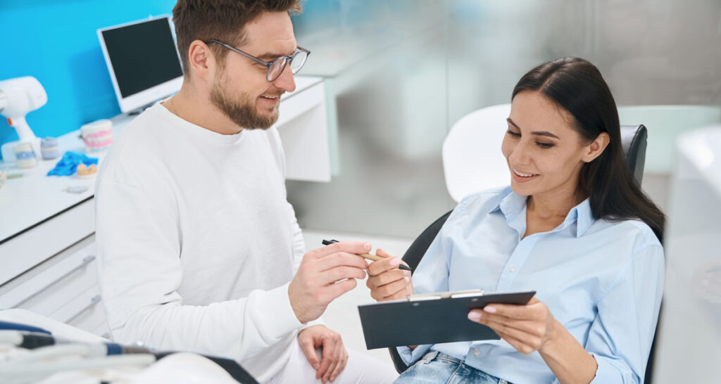 woman communicating monthly payment dentist sat in chair