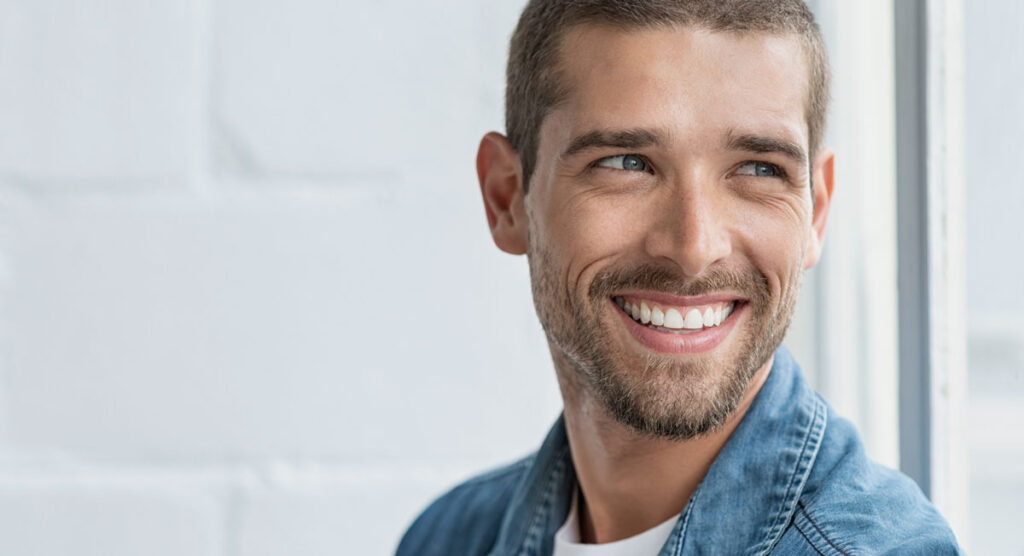 man smiling key benefits of dental implants